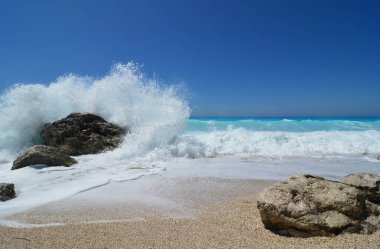 Beyaz sıska ve köpük Ah büyük, siyah taş, İyon Denizi ve mavi, turkuaz dalgalar gökyüzü ünlü Kathisma beach, Lefkada, Yunanistan temizlemek