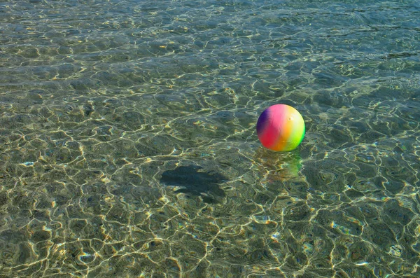 Pelota de playa multicolor en la superficie del mar — Foto de Stock