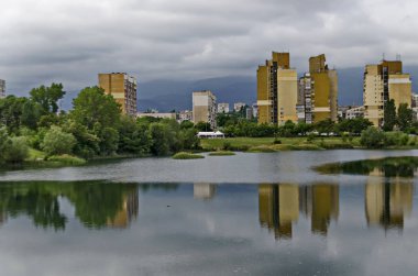 Yerleşim bölgesi mahalle bir göl yeşil ağaçlar, çalılar ve çiçekler, Drujba, Sofya, Bulgaristan ile birlikte bir parçası bahar Panoraması 