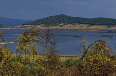 Glade, hill, kıyı, yapraklı ve iğne yapraklı ağaçlar etrafında Batak Baraj Gölü, Rodop Dağları, Bulgaristan ile orman şaşırtıcı sonbahar manzarası