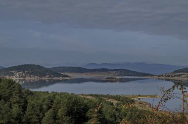 Batak Baraj Gölü, kıyı sonbahar glade, yansıma ve Rodop Dağları, Bulgaristan Hills'te ile orman genel görünümü   