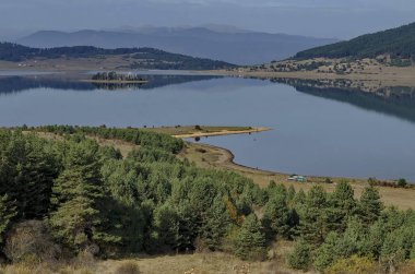 Batak Baraj Gölü, kıyı sonbahar glade, yansıma ve Rodop Dağları, Bulgaristan Hills'te ile orman genel görünümü 