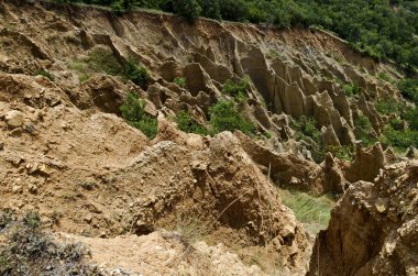Sıradışı şekilli kırmızı ve sarı kaya oluşumları, yeşil çalılar ve ağaçlar, Rila dağının batı payı, Kilustendil bölgesi, Bulgaristan, Avrupa ile ünlü Stobs piramitleri parçası  