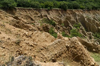 Sıradışı şekilli kırmızı ve sarı kaya oluşumları, yeşil çalılar ve ağaçlar, Rila dağının batı payı, Kilustendil bölgesi, Bulgaristan, Avrupa ile ünlü Stobs piramitleri parçası 