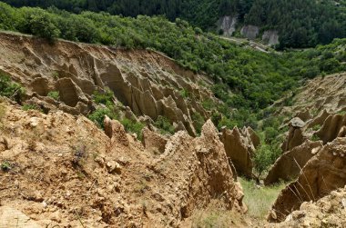 Sıradışı şekilli kırmızı ve sarı kaya oluşumları, yeşil çalılar ve ağaçlar, Rila dağının batı payı, Kilustendil bölgesi, Bulgaristan, Avrupa ile ünlü Stob piramitleri parçası  