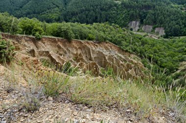Sıradışı şekilli kırmızı ve sarı kaya oluşumları, yeşil çalılar ve ağaçlar, Rila dağının batı payı, Kilustendil bölgesi, Bulgaristan, Avrupa ile ünlü Stob piramitleri parçası  