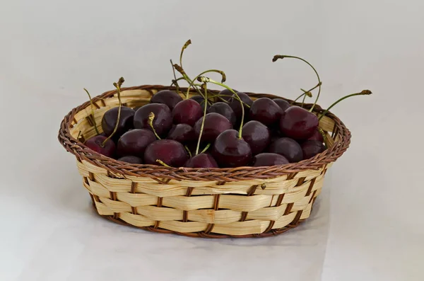 Fresh organic red cherries with stems in a wicker basket, Sofia, Bulgaria