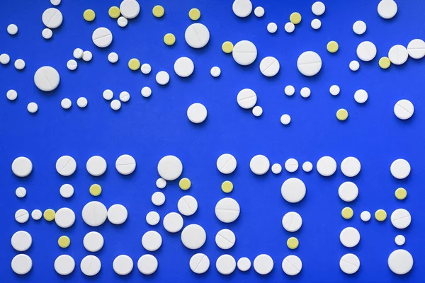 Kerek tabletta rendezett absztrakt kék színű háttér elszigetelt. Tabletták design. Koncepció, az egészség, az egészséges életmód. Másolja a hirdetés terület. Egészségügyi felirat — Stock Fotó