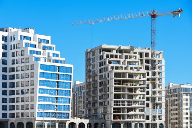 İki özdeş yüksek binalar bir açık mavi gökyüzü, vinç, karşılaştırma karşı beyaz blok inşaatı