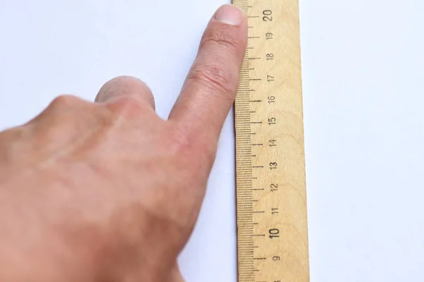 Gesture with your fingers shows a large male penis with a ruler — Stockfoto