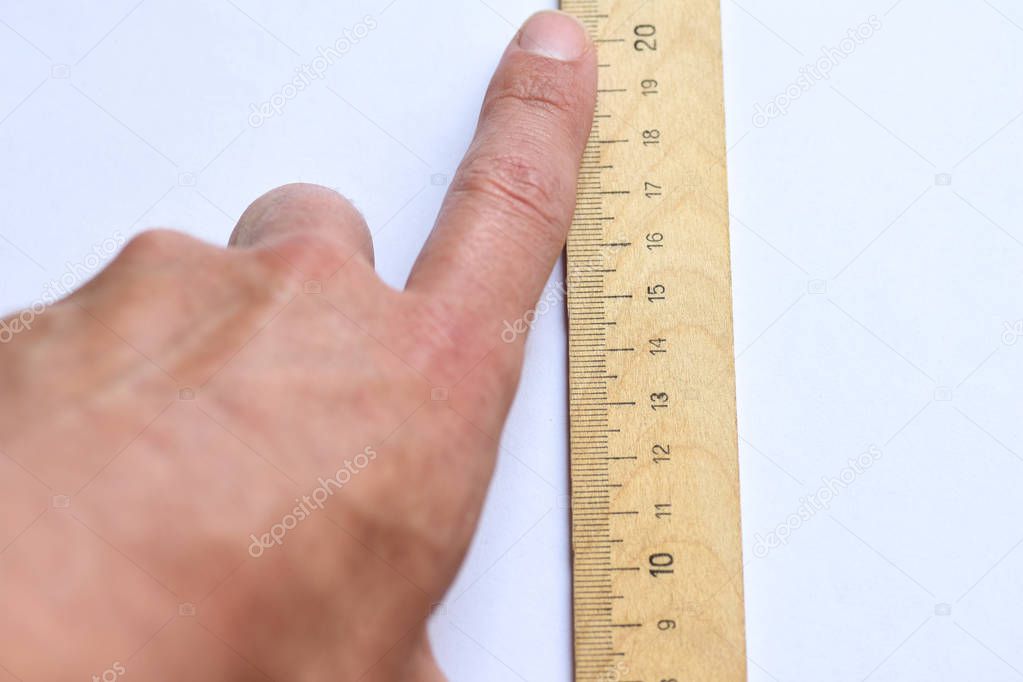 Gesture with your fingers shows a large male penis with a ruler