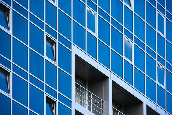 Glass wall of the city building with balconies and open windows — Stock Photo, Image