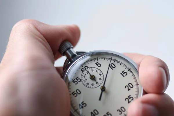 A close-up of an isolated hand presses the stopwatch start button in the sport, measurements, metrology — Stock Photo, Image