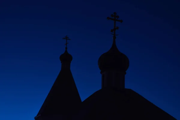 Silhouette de dômes avec croix de l'église orthodoxe contre le ciel bleu dans la soirée — Photo