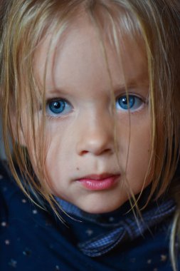 Büyük mavi gözlü Doğu Avrupa'dan, yakın çekim, koyu arka plan üzgün bir romantik küçük kız portresi
