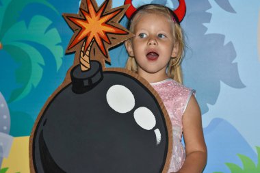 Pembe elbise giymiş bir çocuk bir korsan partide bir oyuncak bombayla çalış