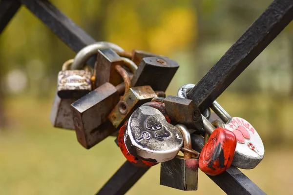 Serrature a forma di cuore appese alla recinzione del ponte, simbolo di amore e fedeltà — Foto Stock