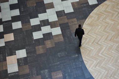 Bir kişi bir zemin renkli seramik fayans yapılan bir daire yürüyor.