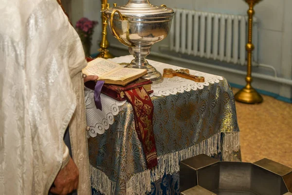 Un prêtre avec une bible à la main accomplit le rite du baptême dans l "Église orthodoxe — Photo