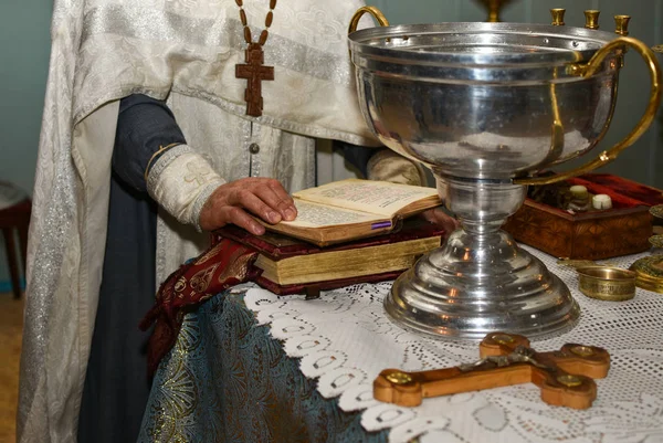 Un prêtre avec une bible à la main accomplit le rite du baptême dans l "Église orthodoxe — Photo