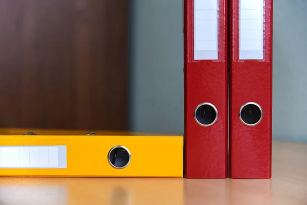 Grandes pastas de cores para documentos na mesa no escritório, close-up, espaço de cópia — Fotografia de Stock