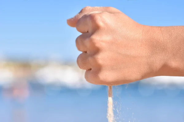 Morski piasek wylaniem dzieci ręce na plaży, zbliżenie — Zdjęcie stockowe