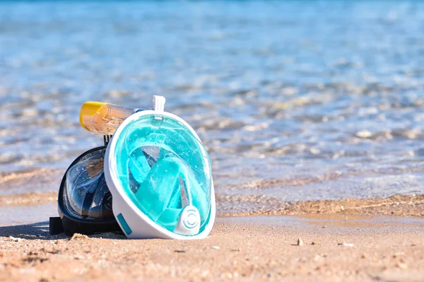 Dwie maski do nurkowania na piaszczystej plaży, w pobliżu morza, kopiować miejsca — Zdjęcie stockowe