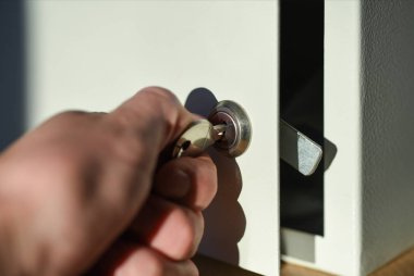 El ofis masası üzerinde beyaz kasa kilidi anahtarı açar