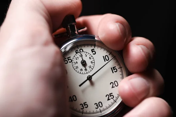 Erkek el başlar analog Kronometre bir siyah arka plan üzerine, yakın çekim, ayrı tut