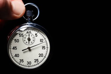 Erkek elini tut analog kronometre siyah bir arka plan üzerinde yakın çekim, ayrı tut, kopya alanı