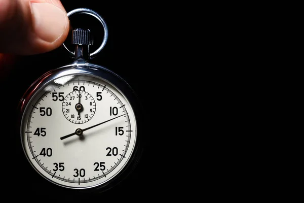 Male hand hold the analog stopwatch on a black background, close-up, isolate, copy space — Stock Photo, Image