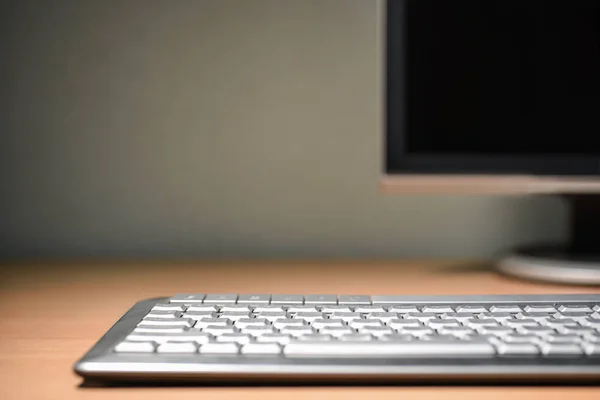 Πληκτρολόγιο υπολογιστή τοποθετημένο στο γραφείο γραφείο μπροστά στην οθόνη, αντίγραφο χώρου — Φωτογραφία Αρχείου