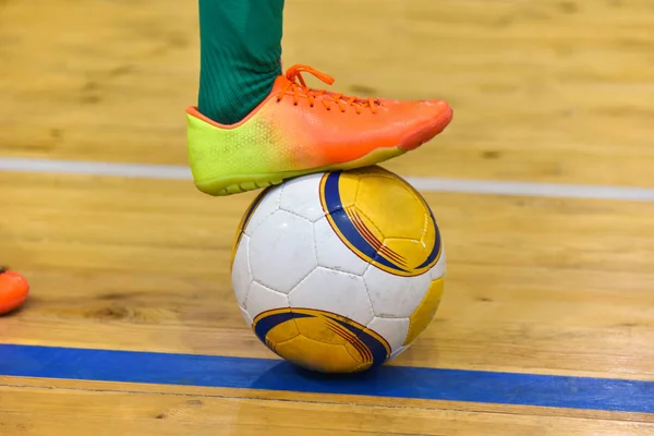 Footballer pé bate a bola depois de uma greve da linha lateral em um mini-futebol no salão — Fotografia de Stock