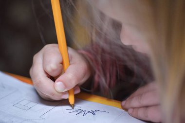 Çocuk yazmayı öğrenir ve kontur çizgi etrafında bir kalem çizer.