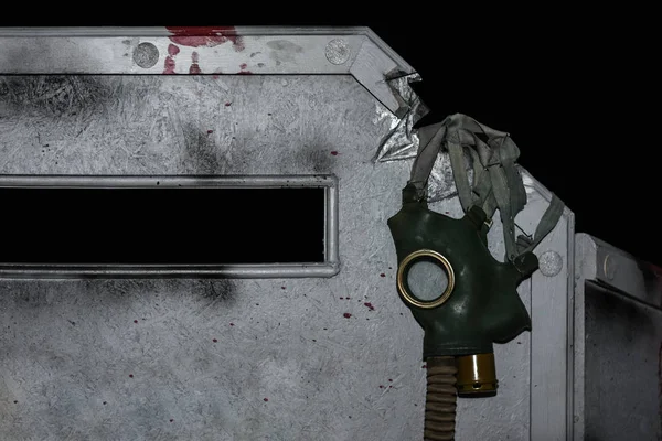 Apokalipszis, gázálarc lóg egy bunkerben egy fekete háttér — Stock Fotó