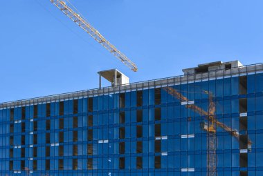 İnşaat altında bir binanın pencerelerini inşa vinç yansıma