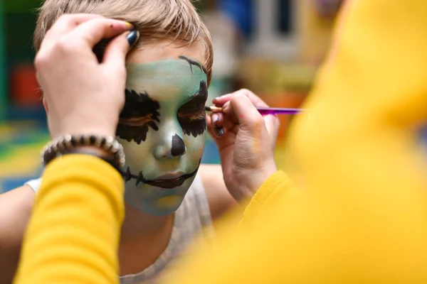 The animator paints the face of the child