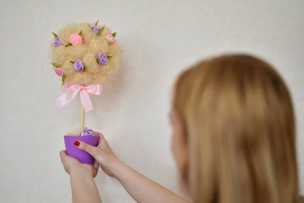 The girl is holding a handmade topiary — Stock Photo, Image