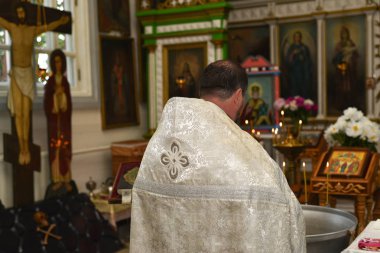 Ortodoks rahip kilisede vaftiz ayini yürütür