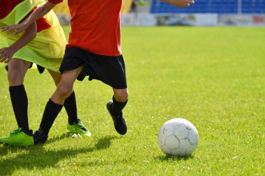 Genç futbolcular stadyumda futbol oynuyor