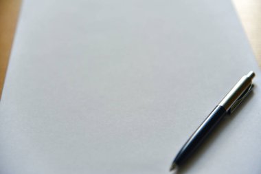 Ofisteki masanın üzerinde beyaz kağıda kalem