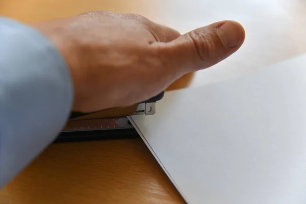 Hand staples paper on office desk — Stock Photo, Image