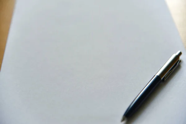 Penna på vitt papper på skrivbordet på kontoret — Stockfoto