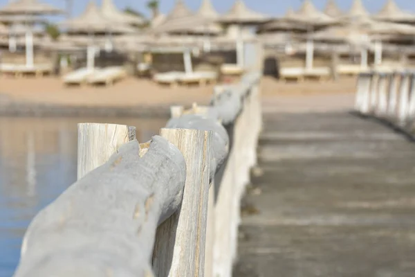 Gamla piren med ett trästaket på stranden av havet stranden — Stockfoto