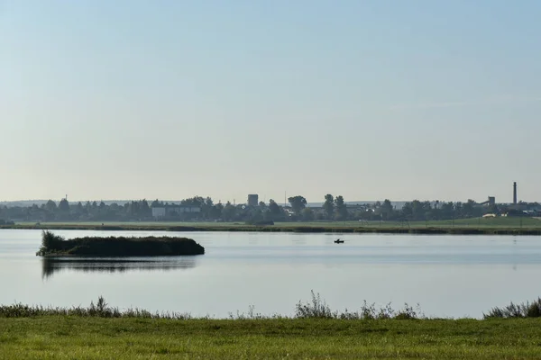 Pêcheur solitaire pêchant sur un lac tôt le matin — Photo