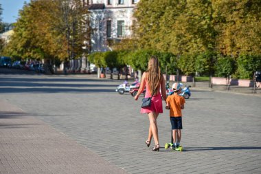 Bir scooter oğlu ile anne şehirde dolaşır