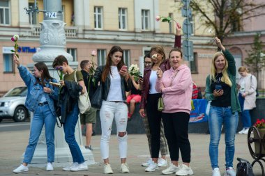 Beyaz bilezikli ve çiçekli insanlar, Belarus, Minsk 'teki Lukashenka hükümetine karşı düzenlenen bir protestoda 13.08.2020.