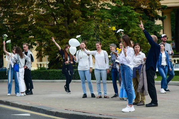 Beyaz bilezikli ve çiçekli insanlar, Belarus, Minsk 'teki Lukashenka hükümetine karşı düzenlenen bir protestoda 13.08.2020.