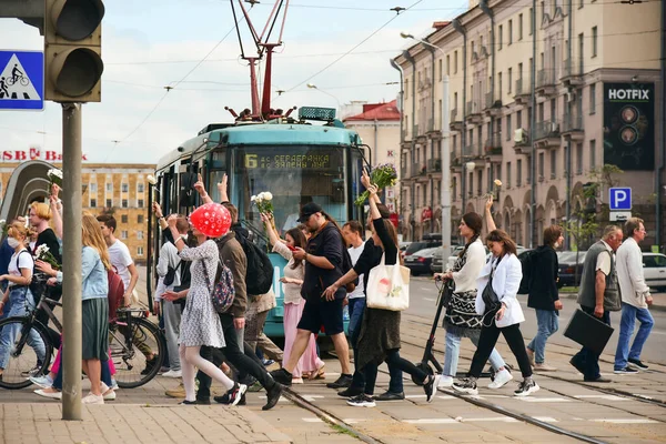 Beyaz bilezikli ve çiçekli insanlar, Belarus, Minsk 'teki Lukashenka hükümetine karşı düzenlenen bir protestoda 13.08.2020.