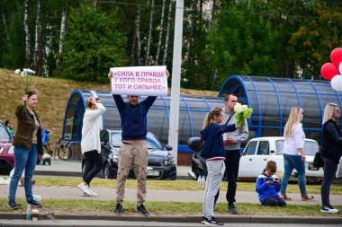 Beyaz bilezikli ve çiçekli insanlar, Belarus, Minsk 'teki Lukashenka hükümetine karşı düzenlenen bir protestoda 13.08.2020.